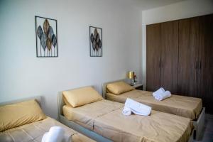 ein Zimmer mit 2 Betten und Handtüchern darauf in der Unterkunft Brewmaster Residence in Is-Swieqi