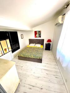 1 dormitorio con 1 cama y suelo de madera en loft des cigales, en Uchaud