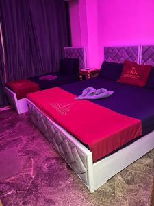 a bed in a room with pink lights on it at New Abdeen palace hostel in Cairo