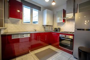 La cuisine est équipée de placards rouges et d'un four avec plaques de cuisson. dans l'établissement TheBrooklyn T3, proche centre-ville-Fibre/Netflix, à Montluçon
