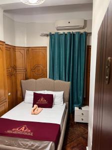 a bed in a room with green curtains at New Abdeen palace hostel in Cairo