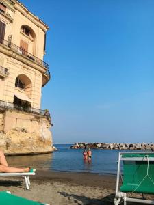 un gruppo di persone che nuotano in acqua in spiaggia di A casa mi a Napoli