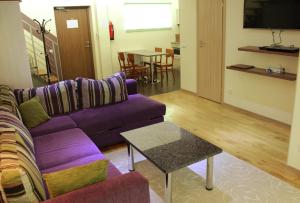 sala de estar con sofá púrpura y mesa en Embrace Hotel & Apartments, en Pärnu