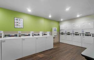 una lavandería con máquinas blancas y una pared verde en Extended Stay America Suites - Tampa - Northeast, en Tampa
