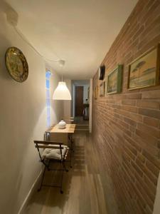 corridoio con tavolo e muro di mattoni di A casa mi a Napoli