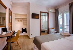 a bedroom with a bed and a desk with a laptop at Hotel Ramis in Ondara