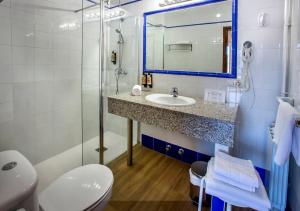 a bathroom with a sink and a toilet and a mirror at Hotel Ramis in Ondara