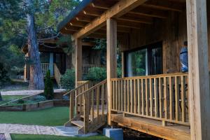 a wooden porch of a house with a large window at Jardín Las Secuoyas in Becerril de la Sierra