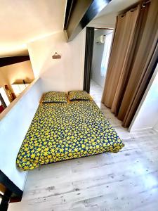 Un dormitorio con una cama con flores amarillas. en loft des cigales, en Uchaud