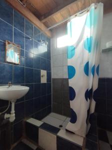 y baño con cortina de ducha y lavamanos. en Wiracocha Hostal Máncora - Surf Camp, en Máncora