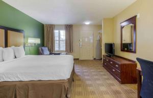 ein Hotelzimmer mit einem großen Bett und einem TV in der Unterkunft Extended Stay America Suites - Fayetteville - Owen Dr in Fayetteville