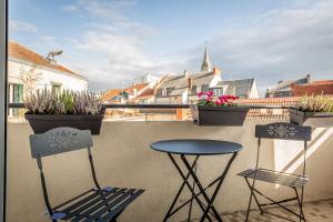 two chairs and a table on a balcony with plants at TheBrooklyn T3, proche centre-ville-Fibre/Netflix in Montluçon