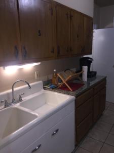 a kitchen with a white sink and wooden cabinets at West End Haven in Hartford