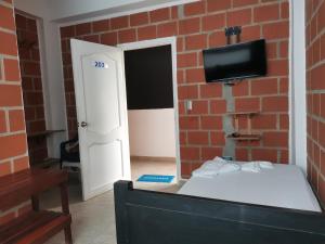 a room with a bed and a brick wall at Hotel OBEGA PACIFIC in Nuquí