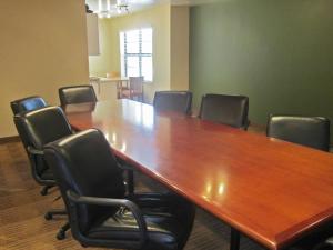 einen Konferenzraum mit einem großen Holztisch und Stühlen in der Unterkunft Extended Stay America Suites - Fayetteville - Cross Creek Mall in Fayetteville