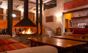 - un salon avec une cheminée et une table dans l'établissement Hotel en Azpitia, à Miraflores