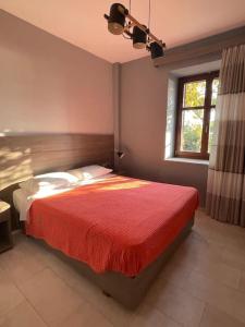 een slaapkamer met een bed met een rode deken en een raam bij The Valley Of the Sun in Mithimna