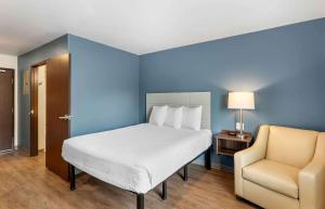 1 dormitorio con 1 cama blanca y 1 silla en Extended Stay America Suites - Denver - Centennial, en Centennial
