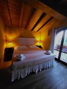 a bedroom with a large bed with two towels on it at Agriturismo Poggiolo in Pilonico Materno