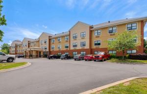 a large building with cars parked in a parking lot at Extended Stay America Suites - Charlotte - University Place in Charlotte