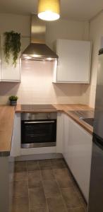 Una cocina con gabinetes blancos y una estufa. en Comfort Stay Rooms, en Portslade-by-Sea