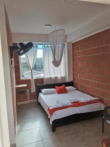 a bedroom with a bed with a brick wall at Hotel OBEGA PACIFIC in Nuquí +51 photos