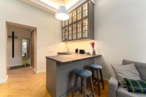 uma cozinha com um balcão e bancos num quarto em Smart park view studio in heart of Riga 5 min to Old Town em Riga