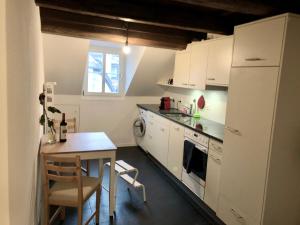 Il comprend une cuisine équipée d'une table et d'un réfrigérateur blanc. dans l'établissement Old Town Apartments, à Berne