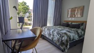 1 dormitorio con cama, mesa y ventana en CityZen escape: blackout ready en Johannesburgo
