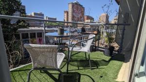 a patio with two chairs and a table on a balcony at CityZen escape: blackout ready in Johannesburg