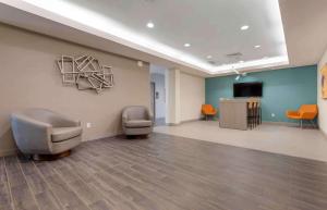 a waiting room with two chairs and a television at Extended Stay America Premier Suites - Greenville - Woodruff Road in Greenville