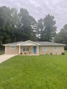 a house with a green lawn in front of it at New Renovated 3BR/2BA home in Cobb County! in Powder Springs