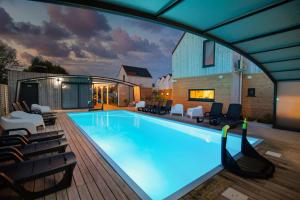 a large swimming pool with chairs around it at Fantazja&spa in Dębki