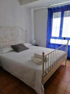 Un dormitorio con una cama blanca con toallas. en ApartamentoS centro ciudad 2 habitaciones ELDA en Elda