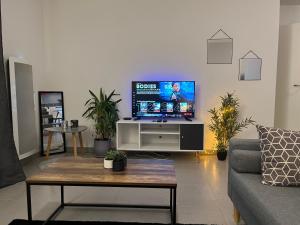 uma sala de estar com uma televisão de ecrã plano sobre uma mesa em Calm in Tours - Appartement T2 em Tours