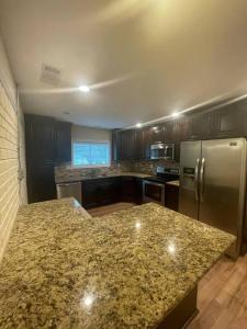 a kitchen with a granite counter top and stainless steel refrigerator at New Renovated 3BR/2BA home in Cobb County! in Powder Springs