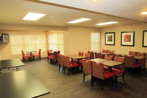 un comedor con mesas, sillas, mesas y sillas y un sillón en Extended Stay America Suites - Atlanta - Alpharetta - Northpoint - West, en Alpharetta