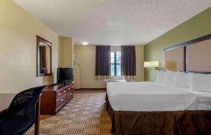 a hotel room with a large bed and a television at Extended Stay America Select Suites - Atlanta - Alpharetta - Rock Mill Rd in Alpharetta