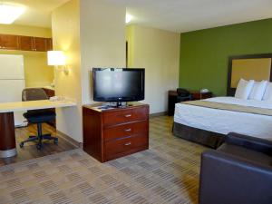 a hotel room with a bed and a flat screen tv at Extended Stay America Suites - Atlanta - Alpharetta - Northpoint - West in Alpharetta