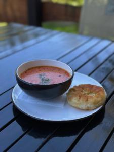 un bol de soupe et une pâtisserie sur une table dans l'établissement Альтана, à Rozluch
