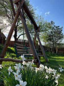 a swing set in a yard with flowers at Альтана in Rozluch