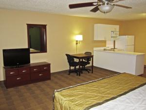 a hotel room with a bed and a table and a kitchen at Extended Stay America Suites - Atlanta - Kennesaw Town Center in Kennesaw