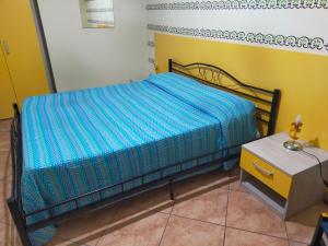 バルチェッローナ・ポッツォ・ディ・ゴットにあるVilla Mannoの青い掛け布団付きのベッド1台