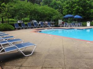 a group of chairs and umbrellas next to a pool at Extended Stay America - Atlanta - Marietta - Interstate N. Pkwy in Atlanta