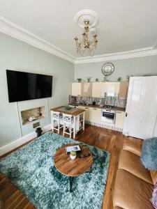 a living room with a table and a couch at Charming 2-Bedroom Apartment Located in Ayr in Ayr