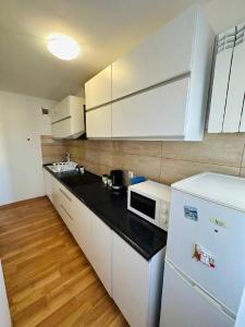 a kitchen with white cabinets and a black counter top at City View Rooms in Warsaw