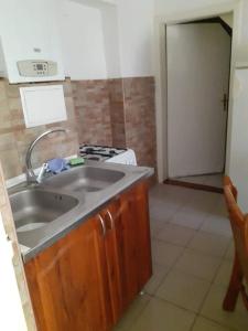 a kitchen with a sink and a stove at Pihenés a Malomtónál privát bérlemény in Tapolca