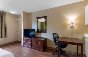 a hotel room with a desk and a television and a bed at Extended Stay America Suites - Atlanta - Perimeter - Crestline in Atlanta