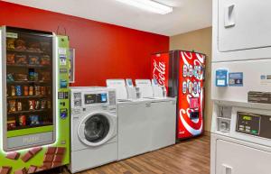 a laundry room with a refrigerator and a washing machine at Extended Stay America Select Suites - Greensboro - Wendover Ave in Greensboro