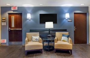 a waiting room with two chairs and a table and a tv at Extended Stay America Suites - Philadelphia - Horsham - Welsh Rd in Horsham